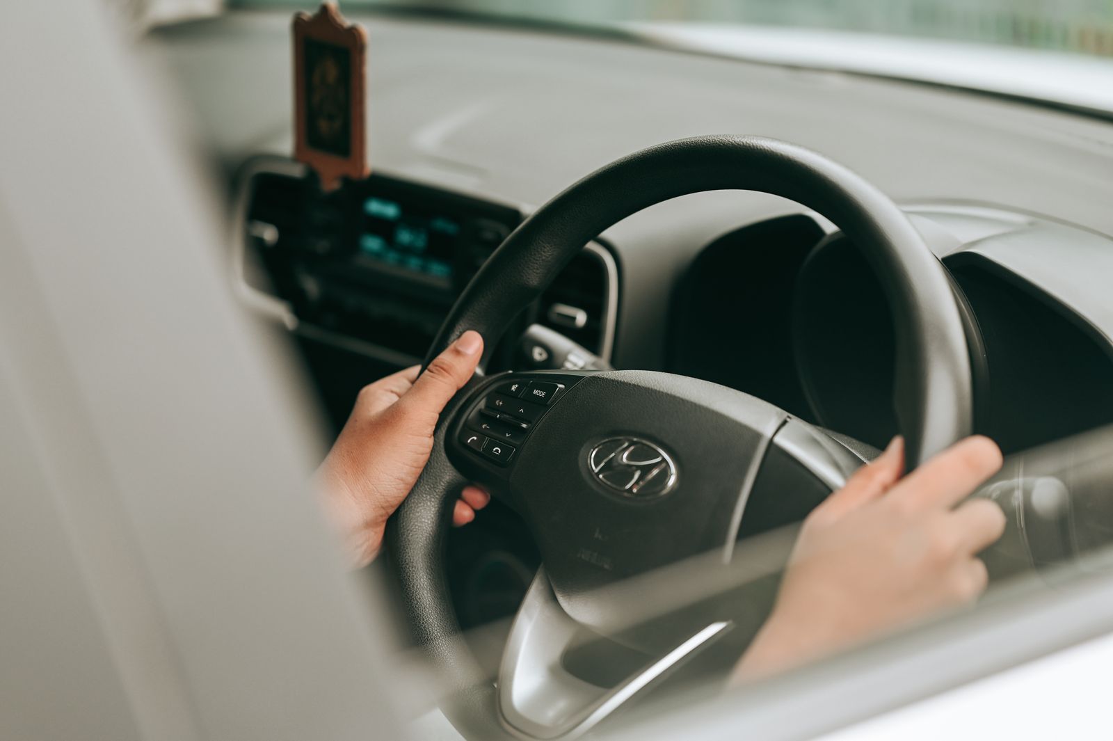 Handen aan het stuur van een auto